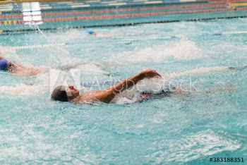 Male swimmer doing backstroke in swimming pool