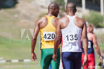 Male track and field athletes on sunny running track