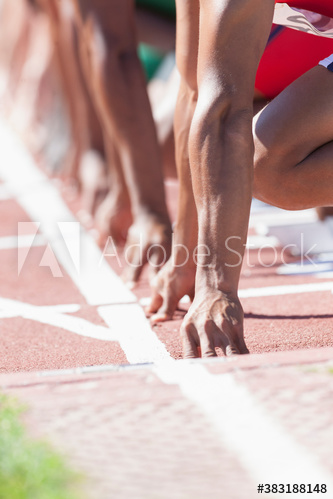 Male track and field sprinters ready at starting line