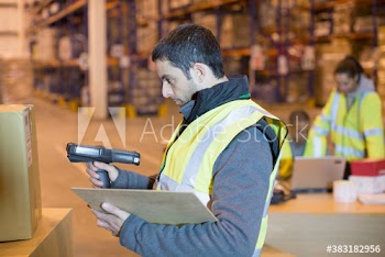 Male worker scanning box in distribution warehouse