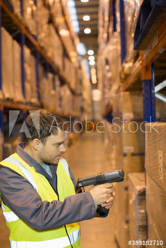 Male worker scanning boxes in distribution warehouse