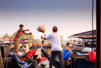 Man About to Catch Brown Bag From Other Man