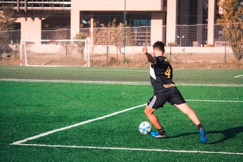 Man About To Kick Soccer Ball On Soccer Field