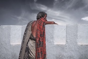 man against concrete wall looking afar