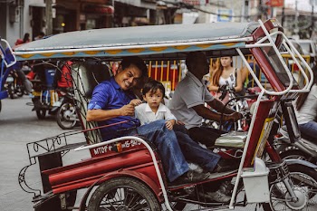 Man And Boy Riding A Tricycle