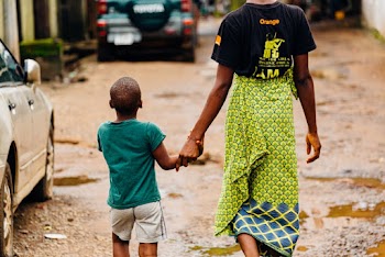 Man and Boy Walking on Beside Vehicle