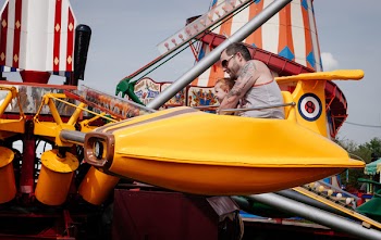 Man and Toddler Riding on Plane Carousel