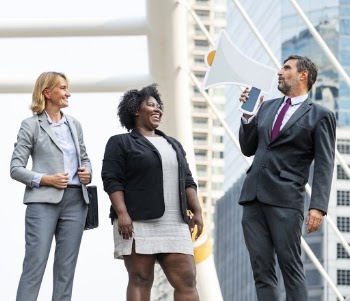 Man and Two Women Standing Beside Building