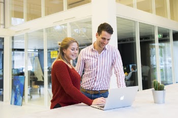 Man And Woman Beside Table With Macbook