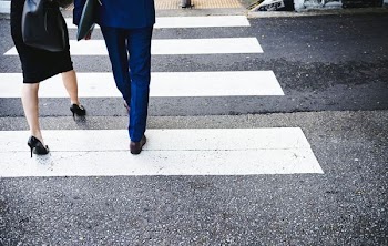 man and woman crossing pedestrian lane