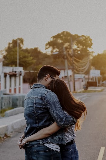 Man and Woman Embracing Each Other on Road