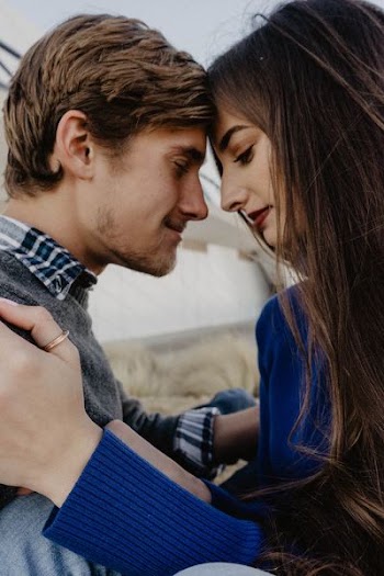 man and woman facing each other and smiling while their eyes closed closeup photo