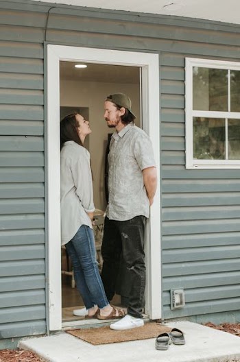man and woman facing each other on door