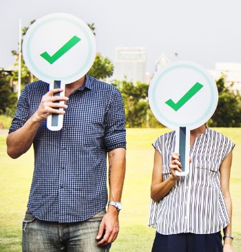 Man and Woman Holding Check Signage