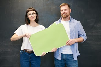 Man and Woman Holding Green Bubble Text Board