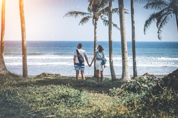 Man and Woman Holding Hand Near Beach Shore Under Sunny Sky