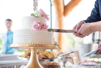 Man and Woman Holding Knife Slicing Cake