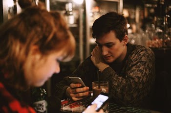 man and woman holding phones