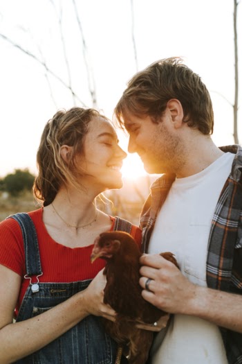 Man and Woman Holding Red Chicken