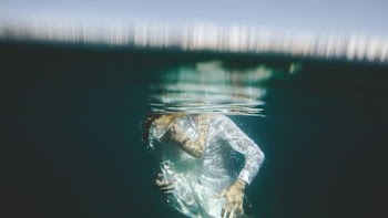 man and woman hug each other under water