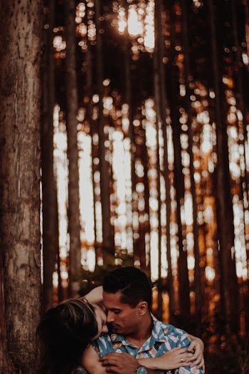 man and woman hugging near tall tree during daytime