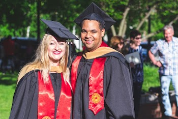 Man and Woman in Black and Red Toga Gown Standing Side by Side
