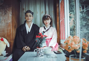 Man and Woman in Front of Red Flowers