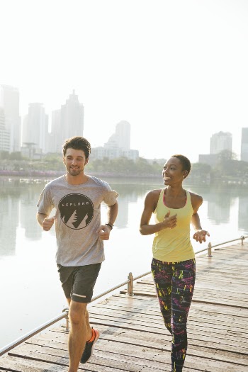 Man and Woman Jogging Near Body of Water