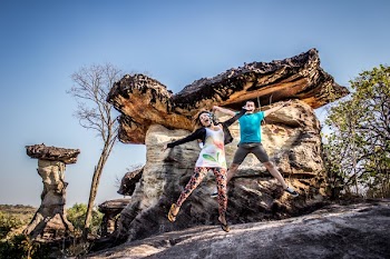 Man and Woman Jumping on Rocky Cliff