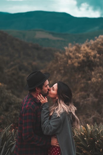 Man and Woman Kissing Near Brown Trees