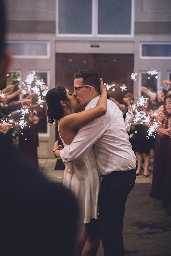 Man and Woman Kissing Near People With Sparkles