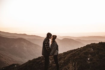 man and woman kissing on mountain during daytime