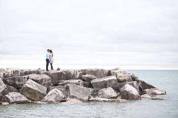 man and woman kissing on shore during cloudy day
