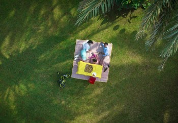 Man And Woman Laying On Picnic Mat