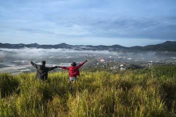 Man and Woman Lifting Hands on Grass Field