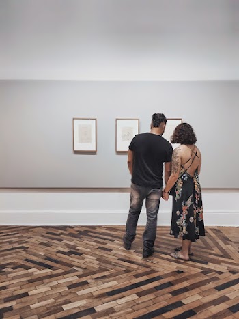 Man and Woman Looking at Wall Decor Inside Building