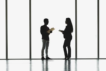Man And Woman Meeting In Front Of Large Windows