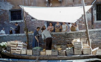 man and woman on boat selling fruits in crate