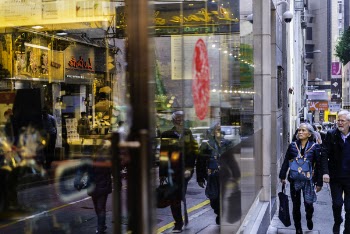Man and Woman Passing Through Building With Glass Facade