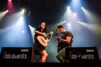 Man and Woman Playing Guitar on Stage at Solidarites