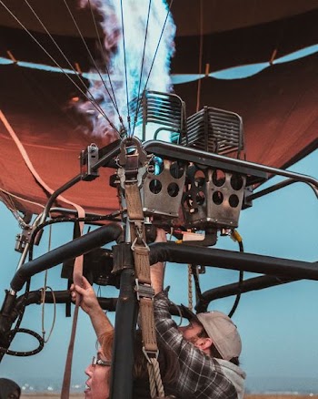 man and woman riding hot air balloon during daytime