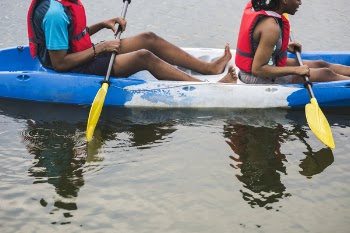 Man and Woman Riding Kayak on Body of Water