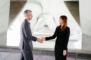 Man and Woman Shaking Hand in Focus Photography
