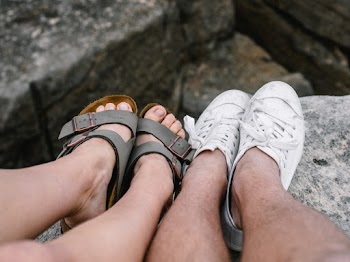 Man and Woman Show Their Feet on Rock