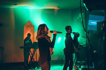 man and woman singing on stage