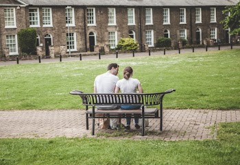 Man and Woman Sits on Black Steel Bench