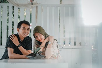 Man and Woman Sitting Beside a Table