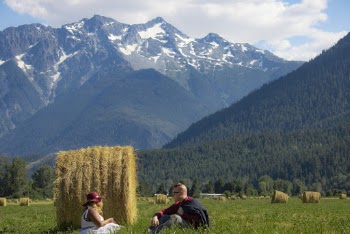 Man and Woman Sitting Beside Hay Bale