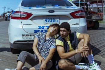 Man and Woman Sitting Beside White Car