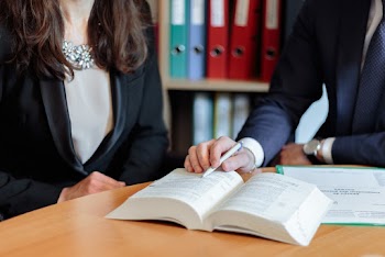 Man and Woman Sitting Facing Book